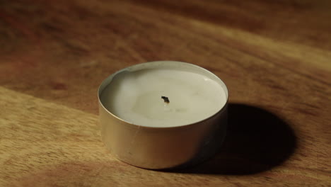 close-up view: burning flame on tea candle is blown out, extinguished