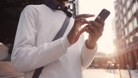 african american businessman through city using smart phone