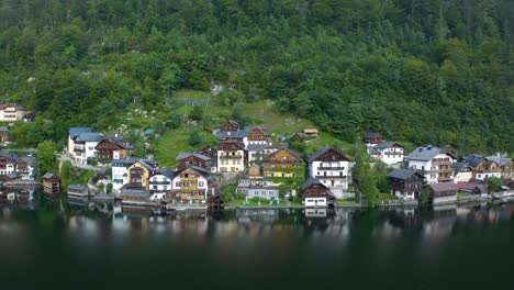 empuje aéreo hacia las casas alpinas austriacas tradicionales en hallstatt, austria en el lago hallstatt