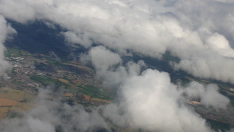 volando aunque las nubes sobre los campos y las casas en un avión de pasajeros