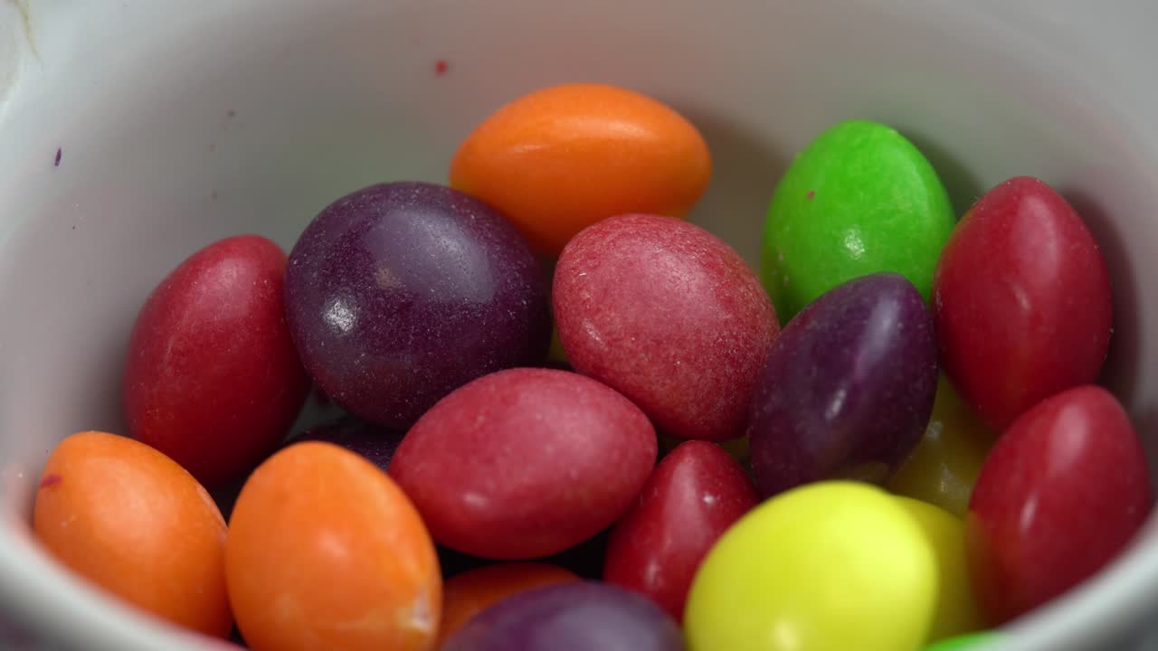 los dulces de frutas de colores giran sobre un fondo negro, los dulces de marco de colores