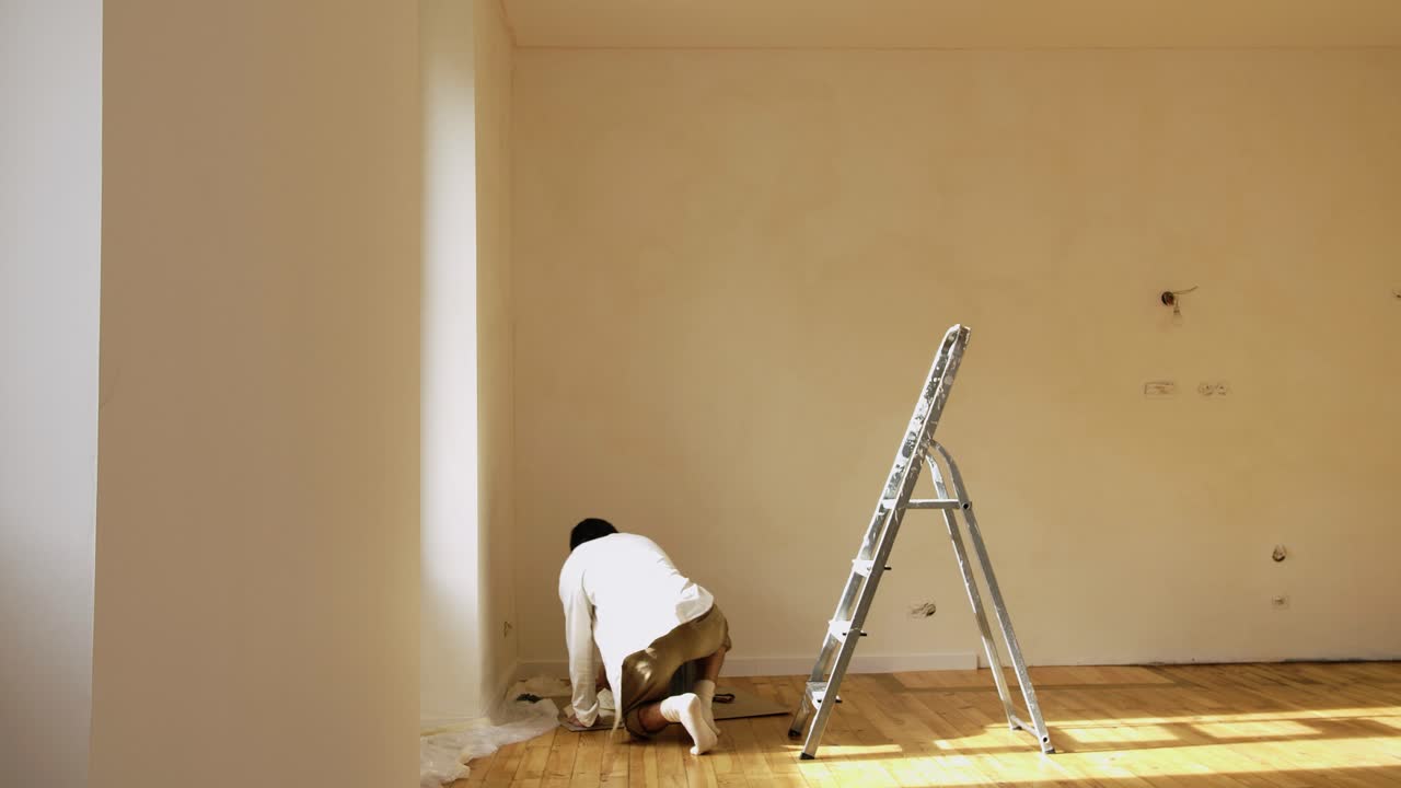 hombre dentro de la habitación con espacio vacío aplicando pintura limewash
