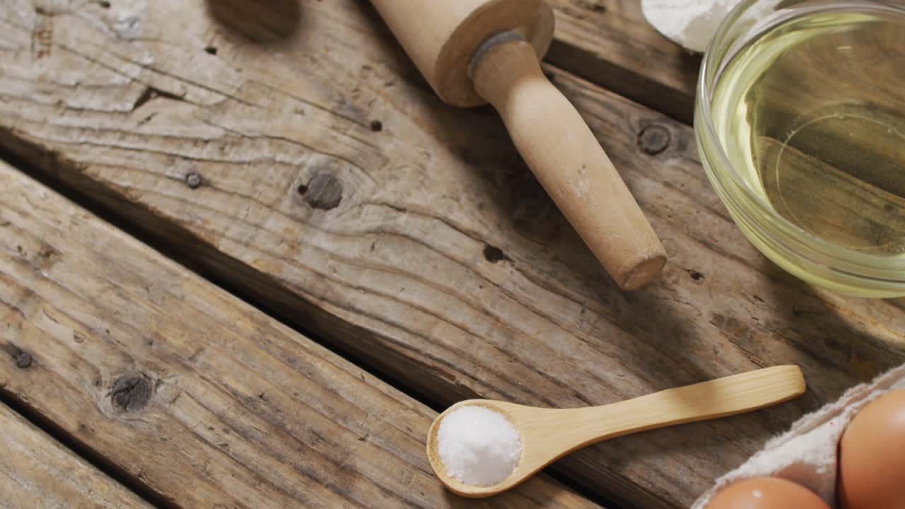 Video di mattarello e ingredienti e utensili per la cottura adagiati su superficie di legno