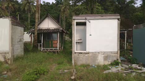 quick right trucking shot of a abandoned and derelict beach bungalow in koh chang thailand due to the effect of covid on global travel and tourism