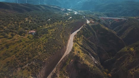 Luftaufnahme-Einer-Straße,-Die-Zwischen-Zwei-Bergen-In-Der-Nähe-Einer-Großen-Schlucht-Gebaut-Wurde