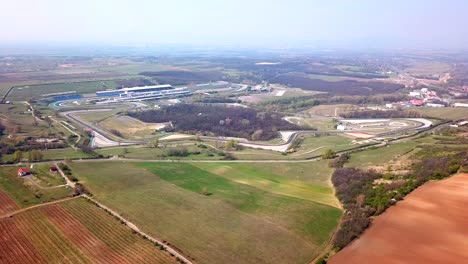 Aerial-view-above-cultivated-fields-and-meadows,-on-a-sunny-day