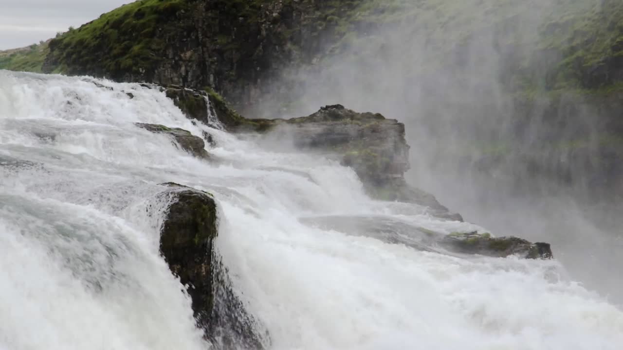 toma estática de agua que fluye a través de las rocas en las cataratas de gullfoss en islandia durante el día
