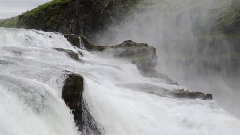 static shot of water flowing through rocks in the gullfoss falls in iceland during daytime