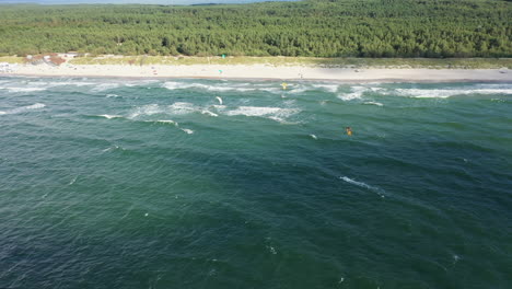 Antenne:-Schwenkfahrt-über-Surfer-In-Der-Nähe-Des-Sandstrandes-An-Einem-Hellen-Tag