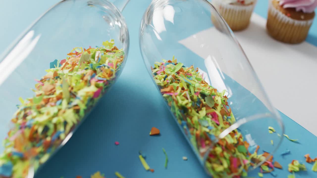 Champagne glasses with confetti and white card on blue background at new year's eve