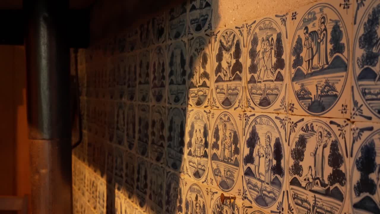 Muro rivestito di piastrelle blu di Delft antiche raffiguranti varie illustrazioni bibliche. Dettaglio di interior design olandese storico e arte dell'artigianato della ceramica