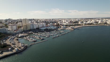 Vista-Panorámica-Aérea-Puerto-Náutico-De-Portimão-En-La-Costa-Del-Río-Arade,-Paisaje-Urbano-De-Edificios-Residenciales