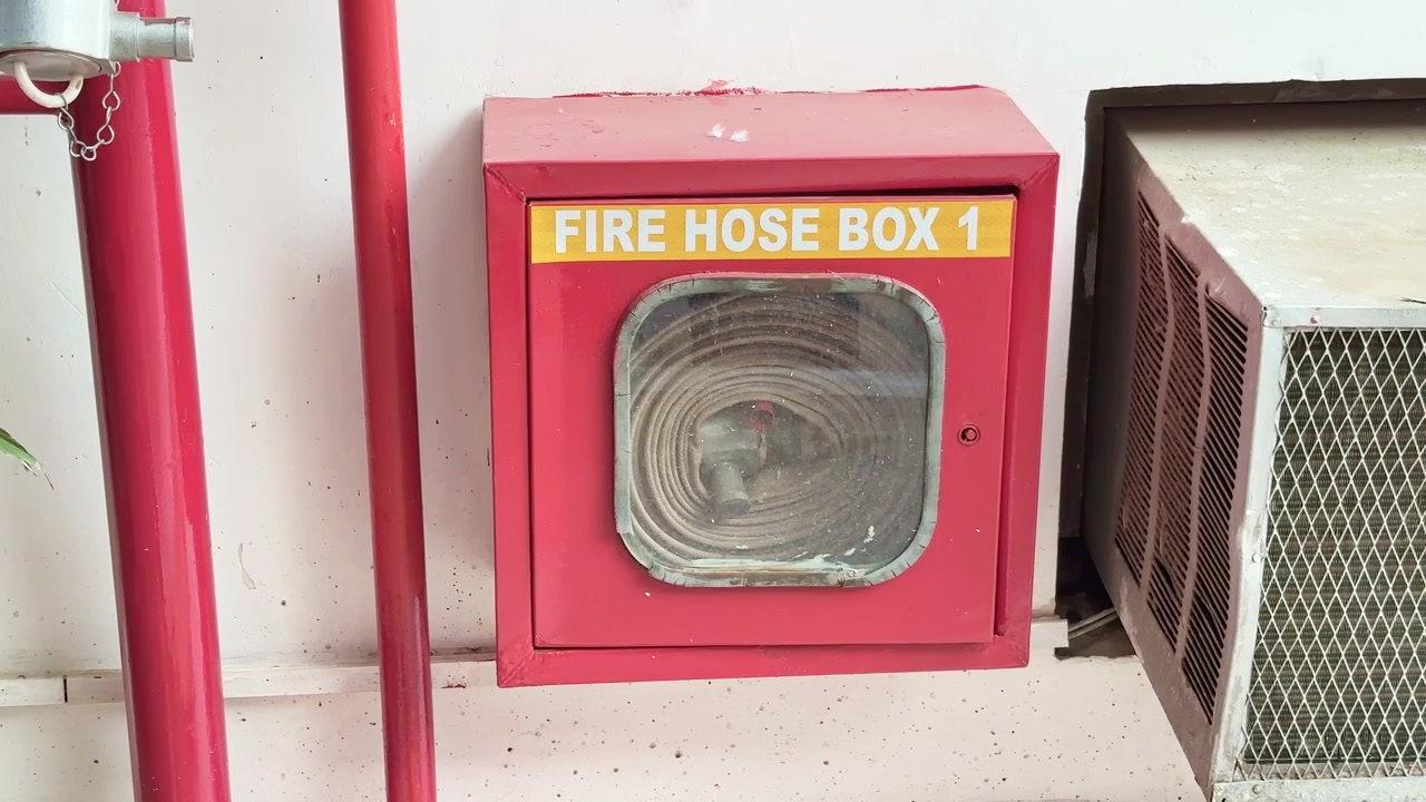 Cassetta antincendio rossa contenente una lancia, una manichetta e diversi altri strumenti antincendio installata nell'edificio.