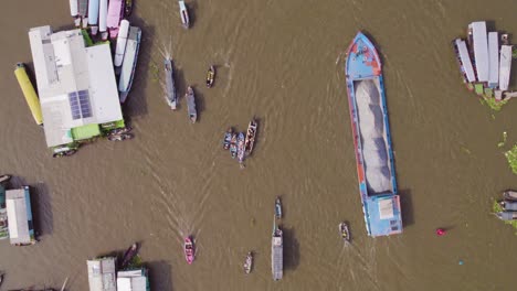 top-down aerial shot of a traditional floating market with local people on boats selling produce at can tho river, cai rang, vietnam