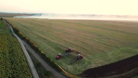 Tractors plowing field during harvest