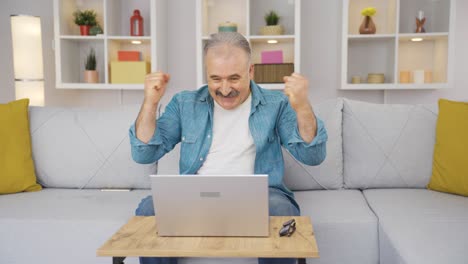 el anciano mirando la computadora portátil se regocija.