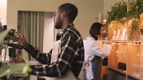 two multiethnic waiters working in a coffee shop 2