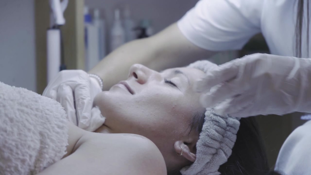 Cliente rilassato che riceve un massaggio viso lenitivo con mani guantate