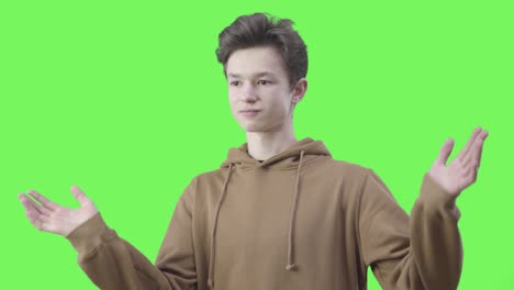 middle shot of surprised caucasian boy raising hands and looking around. portrait of amazed teenager showing emotions at chromakey background. reaction, shock, lifestyle. green screen.