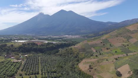 panoramic view of volcan de fuego and acatenango towering over cultivated farmlands, forests and valleys in guatemala