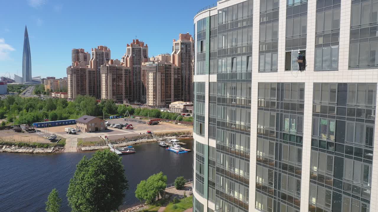 러시아 상트페테르부르크의 배경에 오코노미야키 구조가 있는 건물 창문 청소부의 공중 드론 정적 샷