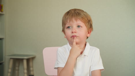 preschooler raises hand answering teacher question