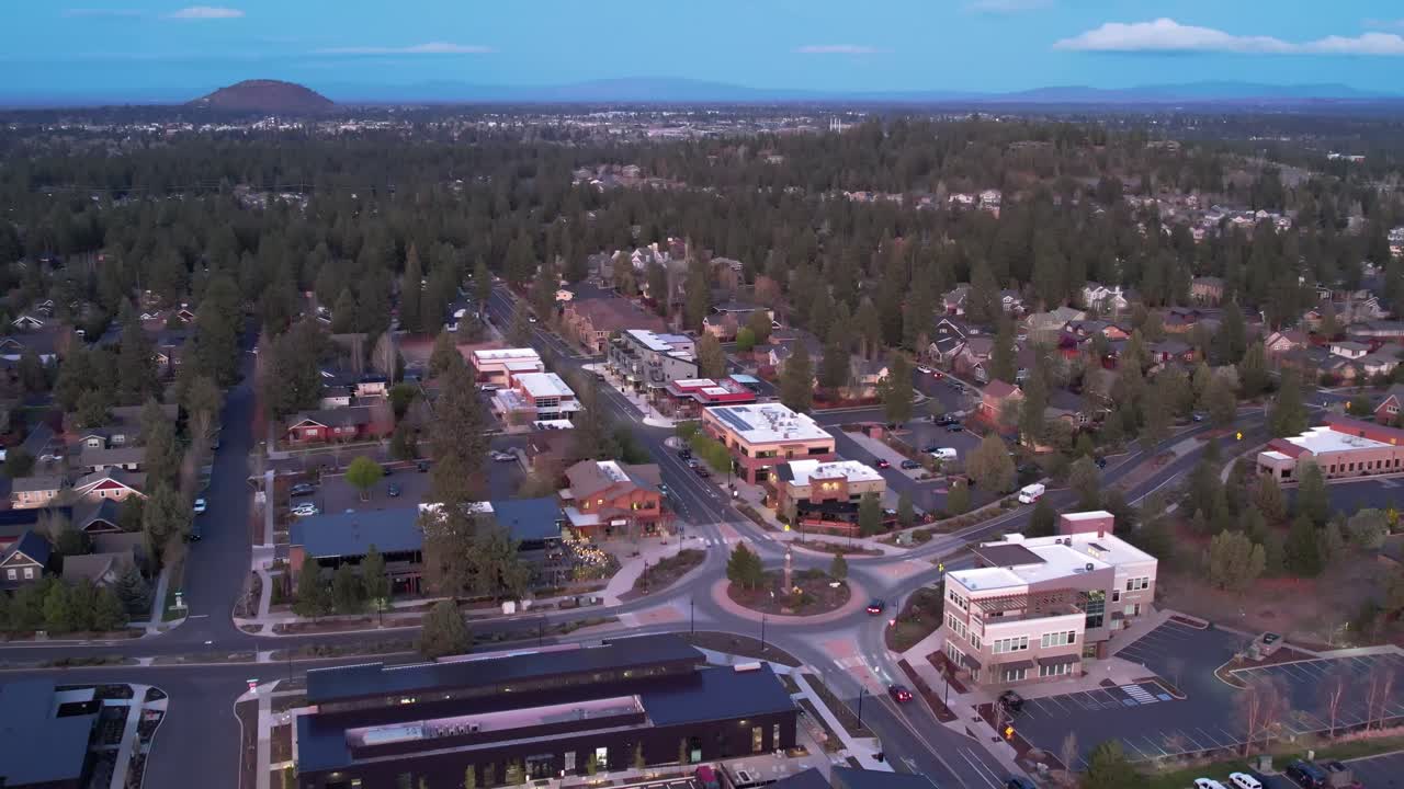 toma de drone de un vecindario en bend, oregon, con negocios y rotonda.