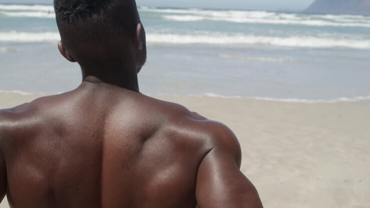 Shirtless man relaxing on beach in the sunshine 4k