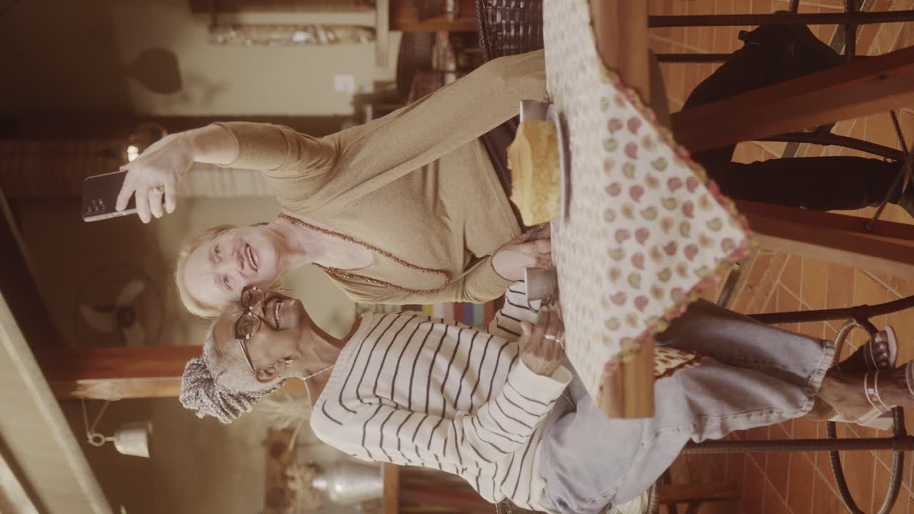 Two Senior Women Taking a Selfie Together at a Cafe