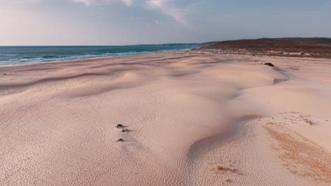 expansive sandy beach along the coastline of portugal at sunset