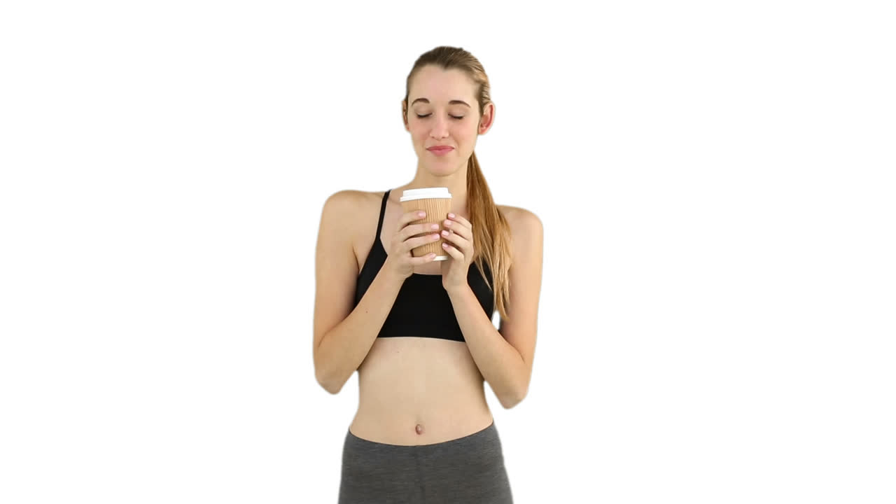 Modella in forma che beve da un bicchiere usa e getta