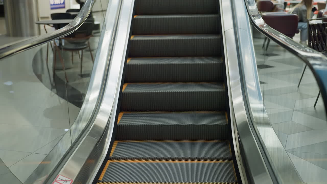 An escalator in motion at a modern shopping mall. shows the moving steps and sleek design of the escalator, highlighting the smooth ride and contemporary environment