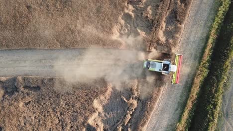 combine-harvester-moving-backwards-trough-the-field-trough-the-dust-it-has-created