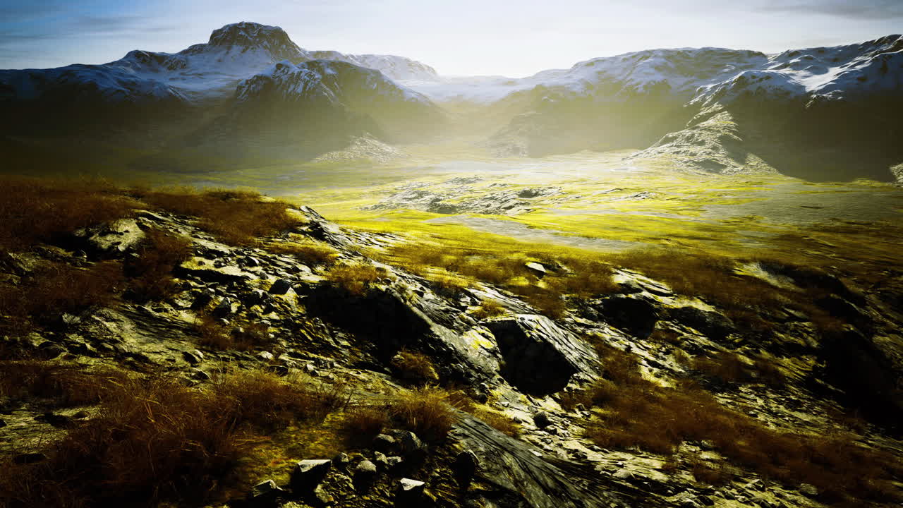 Vast landscape showing rugged mountains and lush valleys under sunlight