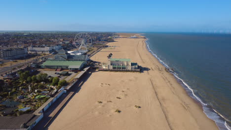 great yarmouth wellington pier and beach aerial shot, norfolk coast. this is a traditional british seaside town with amusement attractions and arcades. wind turbines can be seen in the background