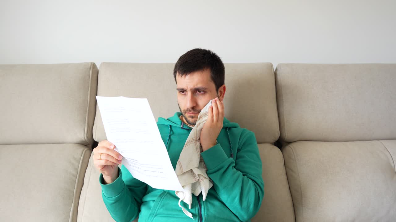 paciente en el sofá leyendo recomendaciones médicas después de la extracción de dientes