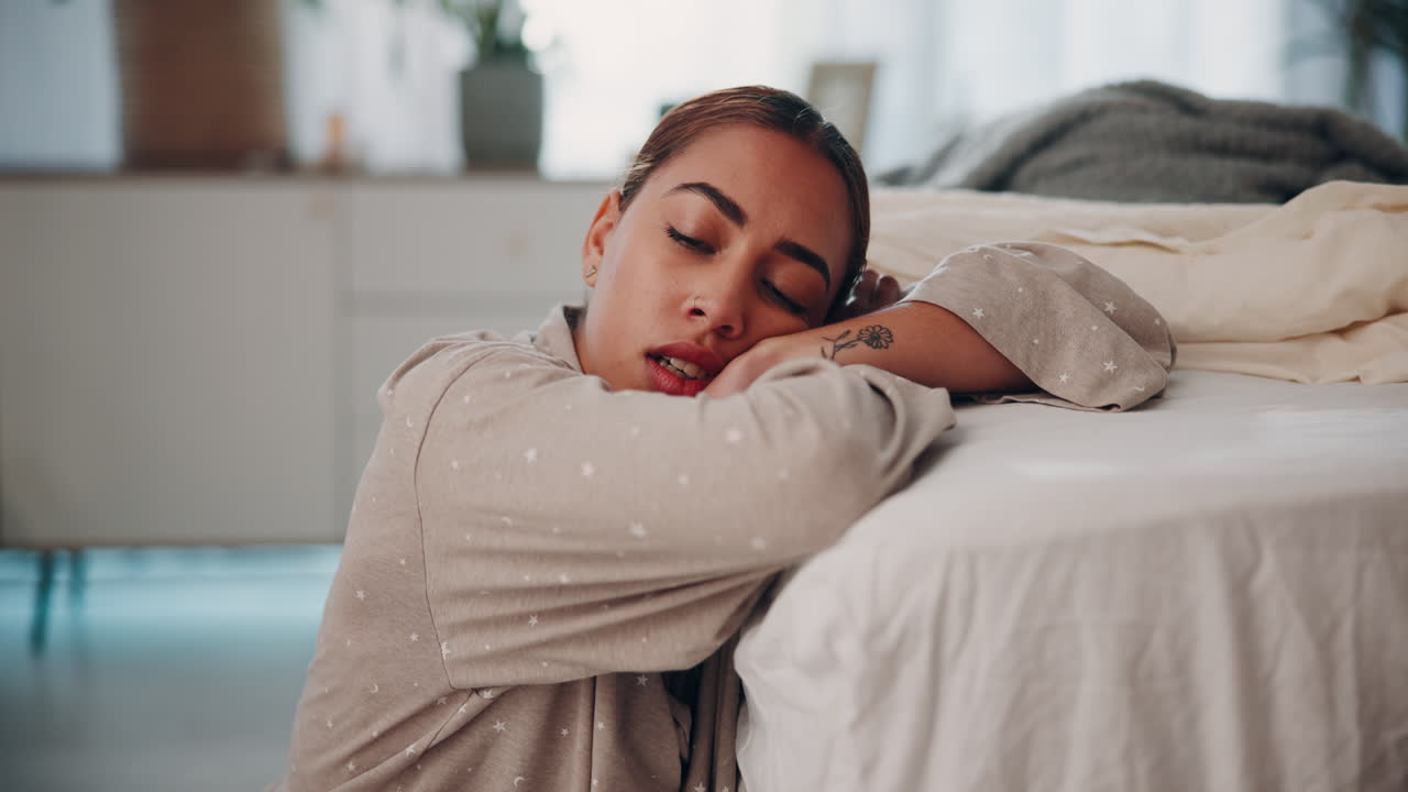 Sad woman sitting on the floor in a bedroom