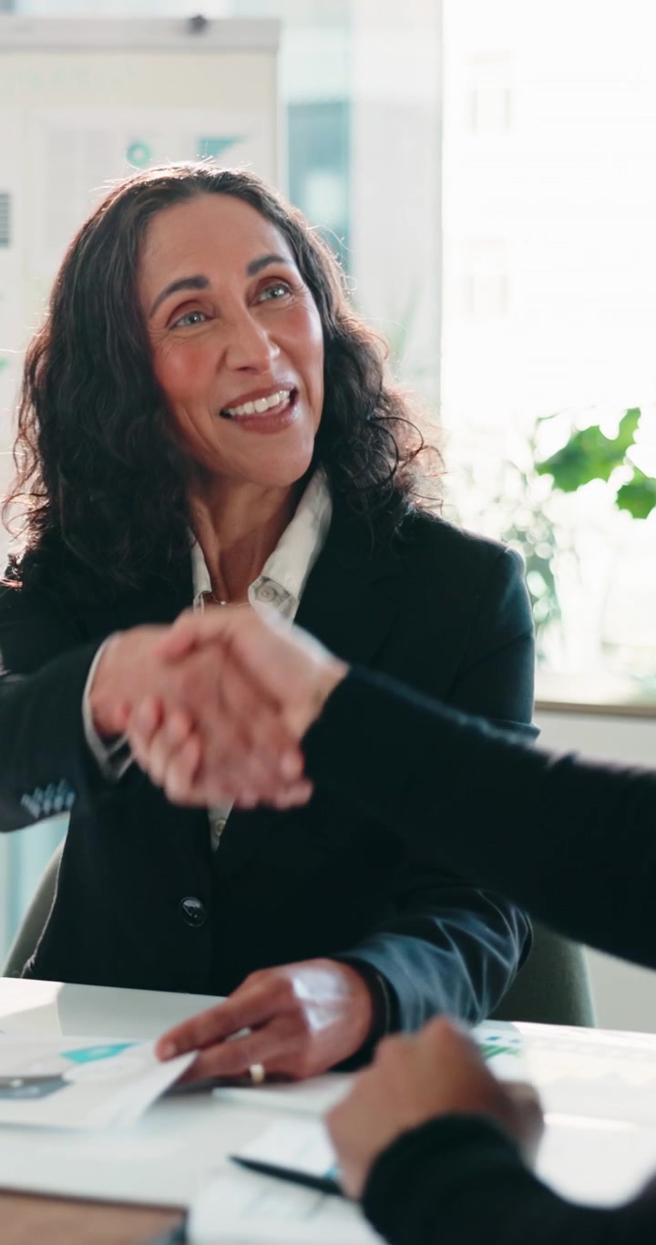Donna d'affari professionista che stringe la mano durante una riunione in ufficio