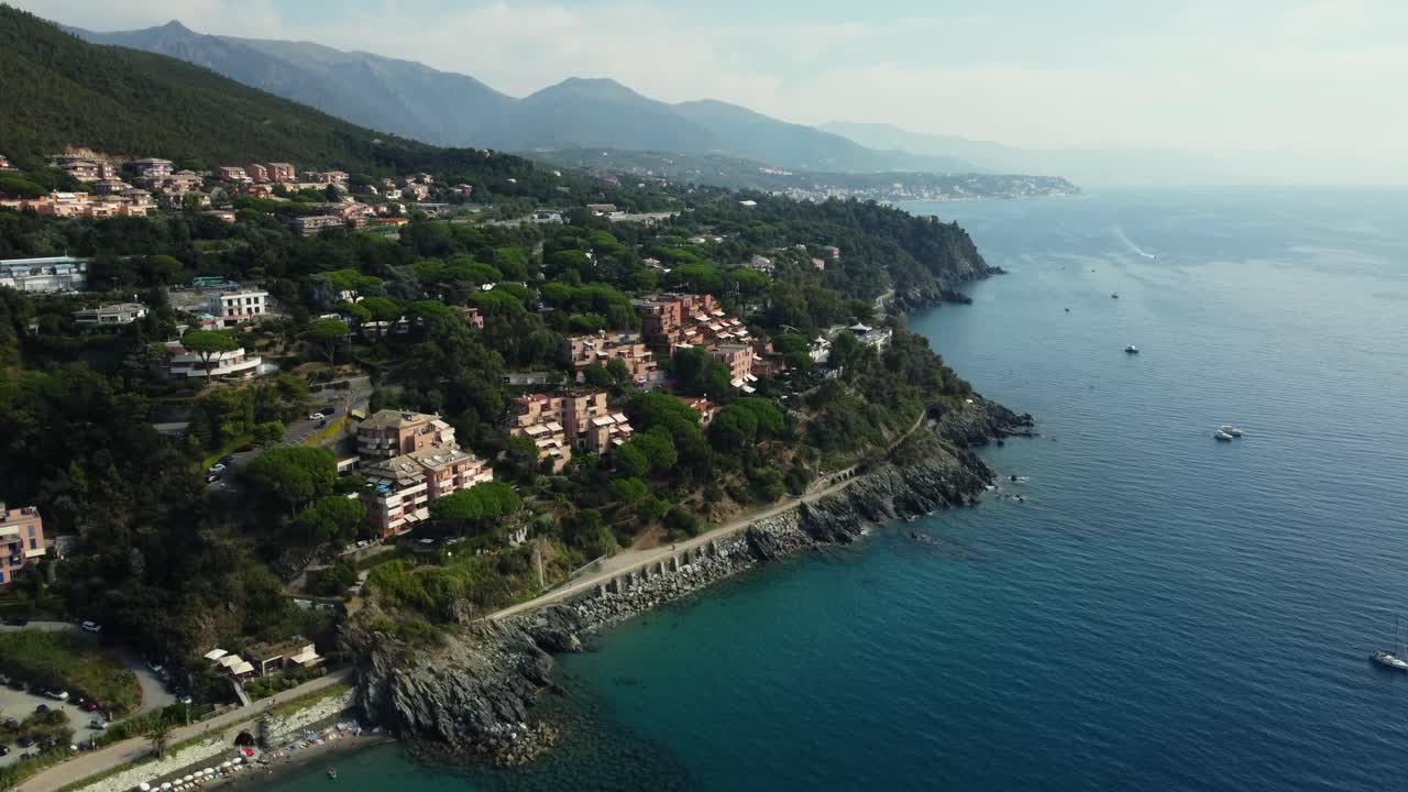 Vista aerea di una costa con edifici, alberi e montagne