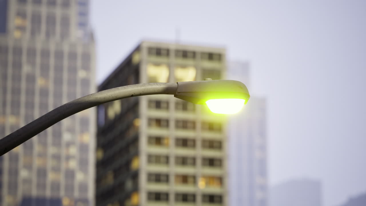Bright streetlight illuminating urban buildings during twilight hours