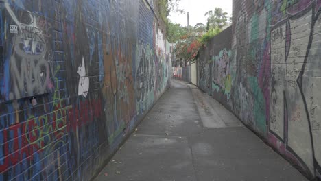 callejón vacío con coloridos artes de graffiti en una pared de hormigón - tiro lateral