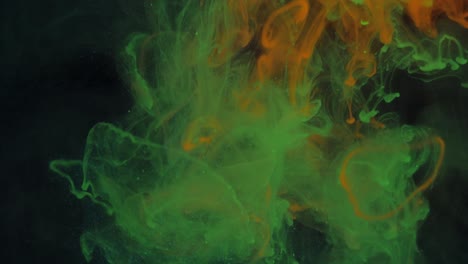 mezclando partículas de colores brillantes de pintura verde y roja en el humo.