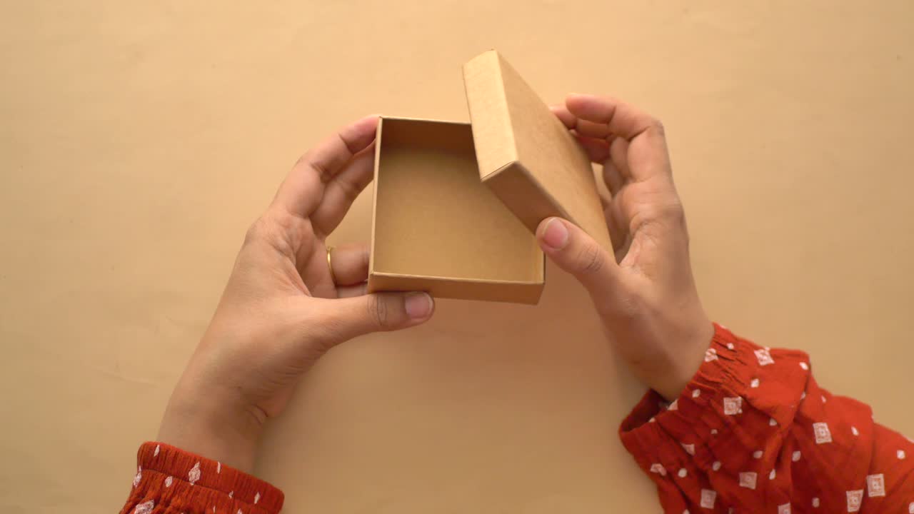 빈 갈색 선물 상자를 들고 있는 손