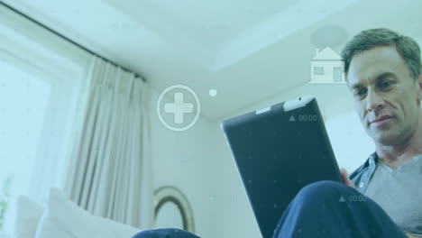 using tablet, man with health and home icons animation over living room background