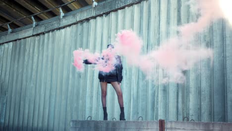 girl standing on street with smoke bomb in hand. woman holding smoke grenade