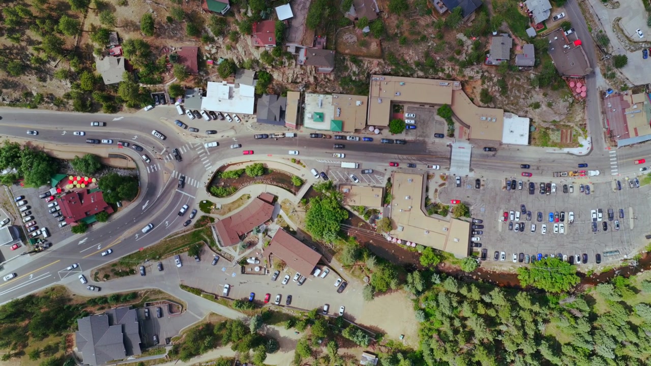 Centro di Evergreen, piccola città di montagna, vista aerea con drone a volo d'uccello, edifici commerciali sulla strada principale, Colorado, Upper Bear Creek, auto nel parcheggio, Front Range delle Montagne Rocciose, mattina soleggiata estiva e primaverile, a sinistra