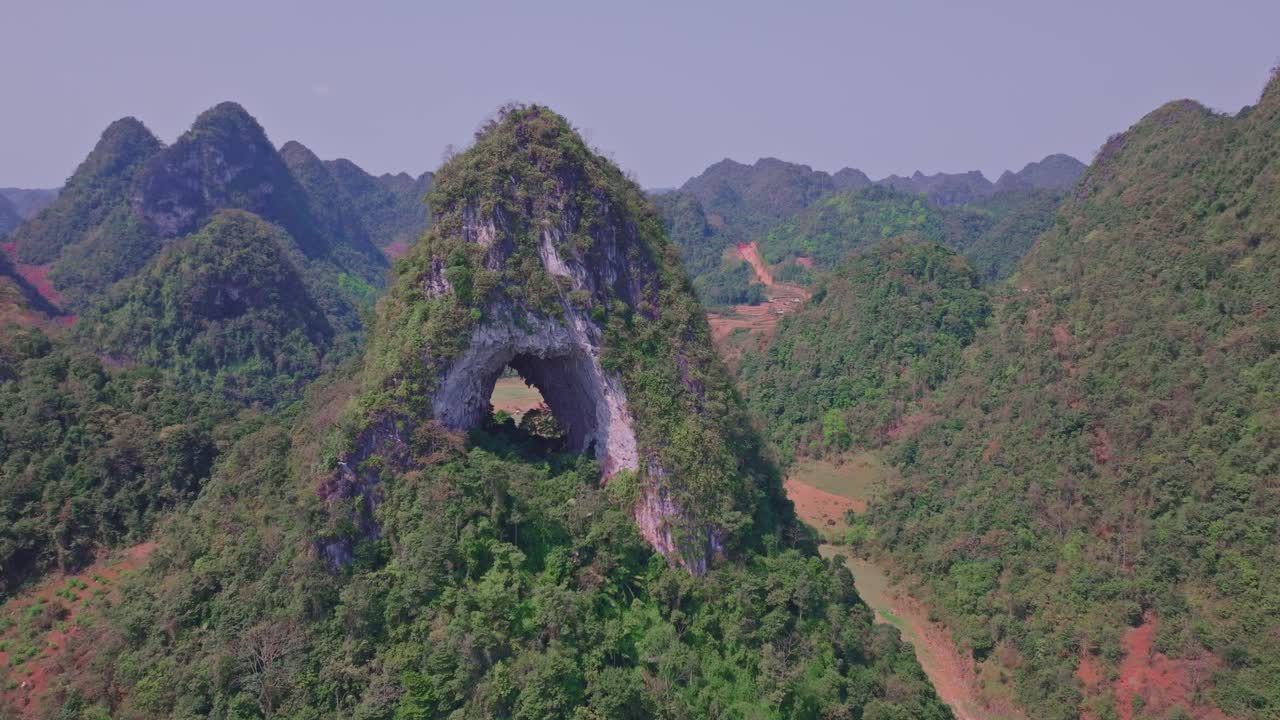 el dron vuela sobre el único tapete que la montaña con un gran agujero en el medio, mostrando el paisaje verde exuberante y la notable formación natural