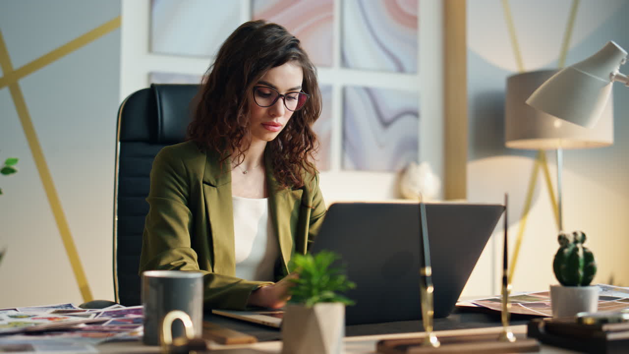 gerente atractivo centrado en el portátil escribiendo informe en el lugar de trabajo de la oficina de cerca.