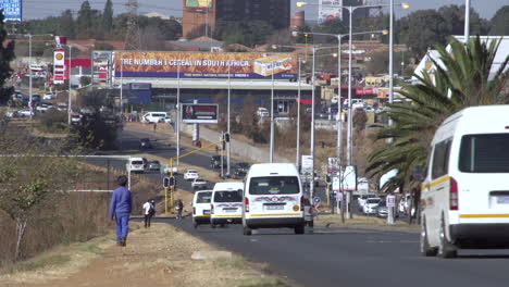 commuter taxis and cars travel along one of the main roads in the township of soweto in johannesburg, south africa.
