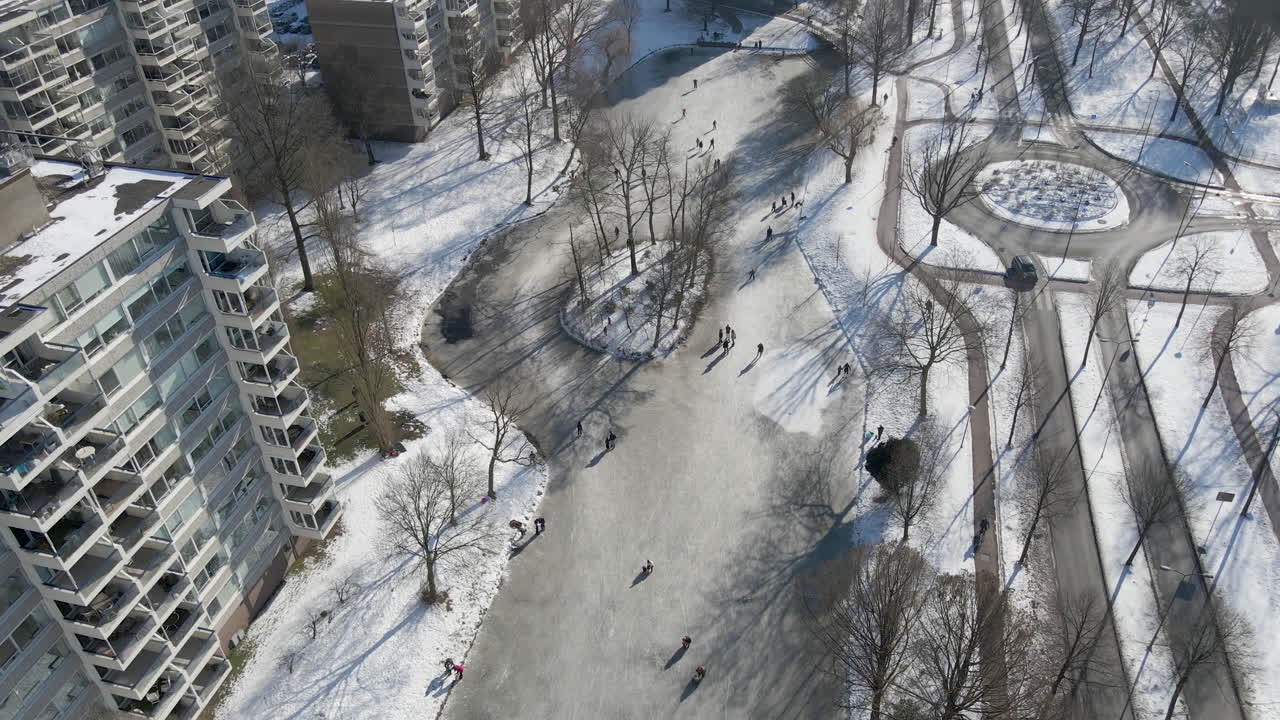 Aerial of people skating on frozen pond in the Netherlands